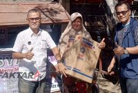 Ketua DPD NasDem Bolmut Syamsudin Olii bersama Sekretaris Abdul Muthalib Posangi menyerahkan bantuan kepada pelaku UMKM dan alat tulis bagi siswa kurang mampu di Kaidipang.(Foto: dok*)