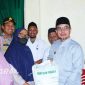 Bupati Bolmut Sirajudin Lasena menyerahkan secara simbolis bantuan cadangan pangan pemerintah tahap II di Kantor Camat Kaidipang.(foto: poket/*)